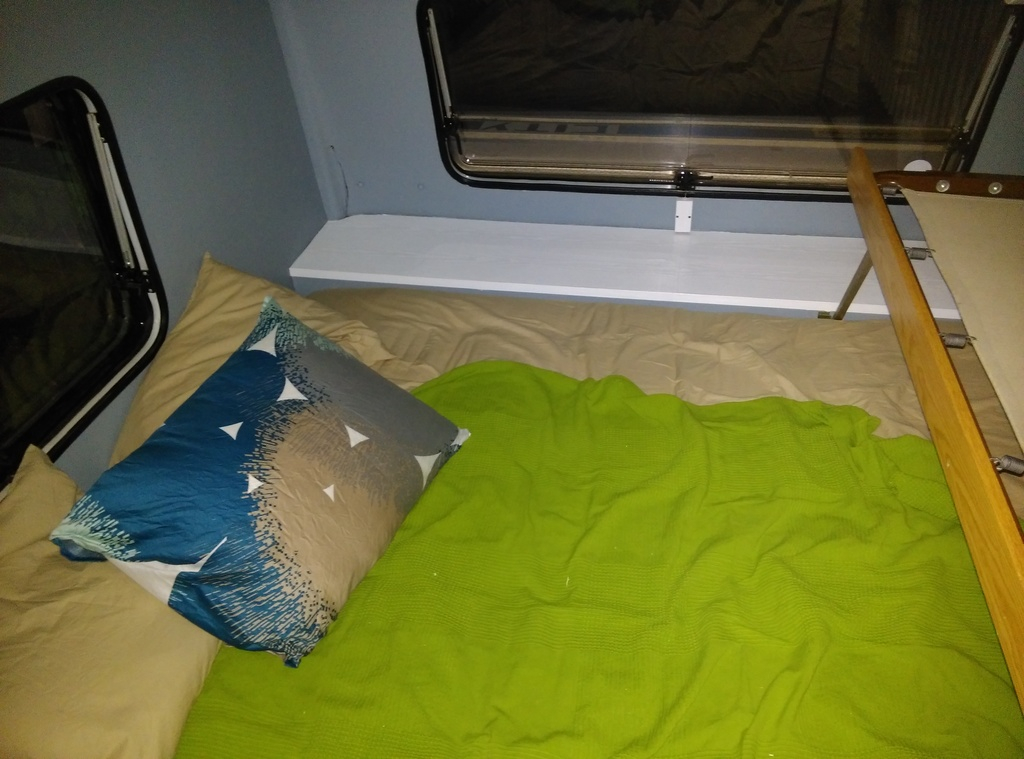 Sängen bäddad och fin vid hyllan